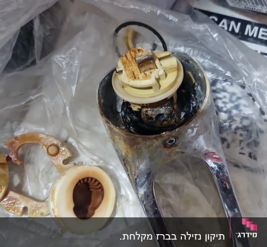 חלקי ברז מפורקים על שקית פלסטיק